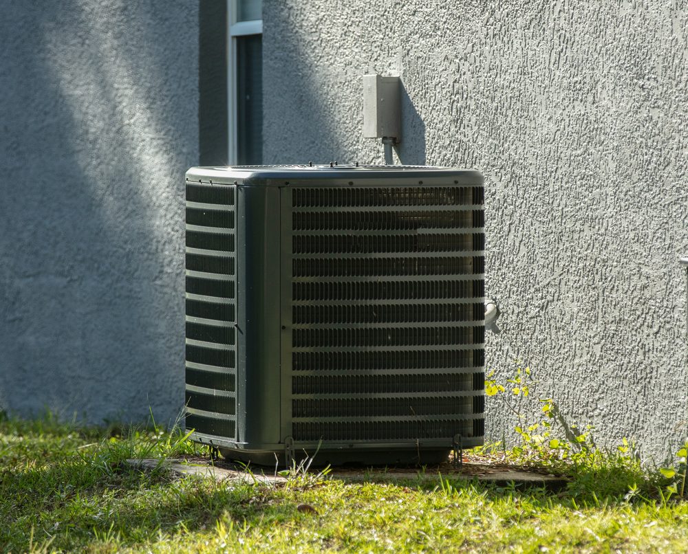 Residential condenser beside a home